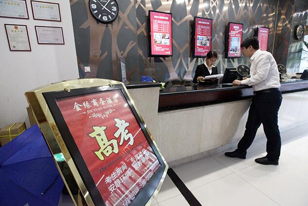 一位家长正在向酒店咨询高考房事宜