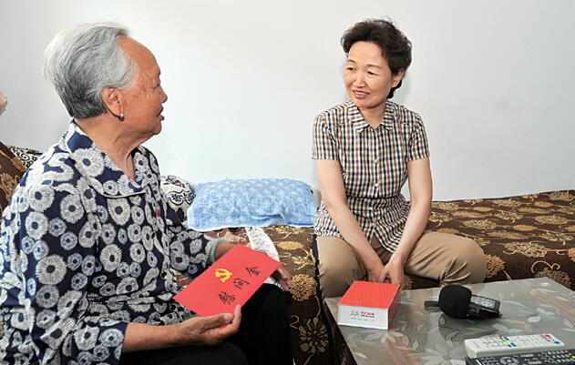在老党员申桂林家,张九萍与老人亲切交谈,详细了解她的生活情况和身体状况。 本报记者 袁文忠 摄