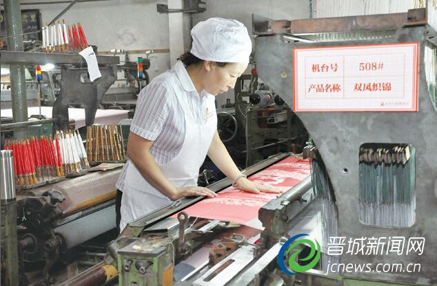 潞绸织造技艺第四代传人窦军兰正在车床上制作织锦被面。